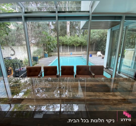 בריכה חיצונית עם ציוד ניקוי ליד שולחן זכוכית